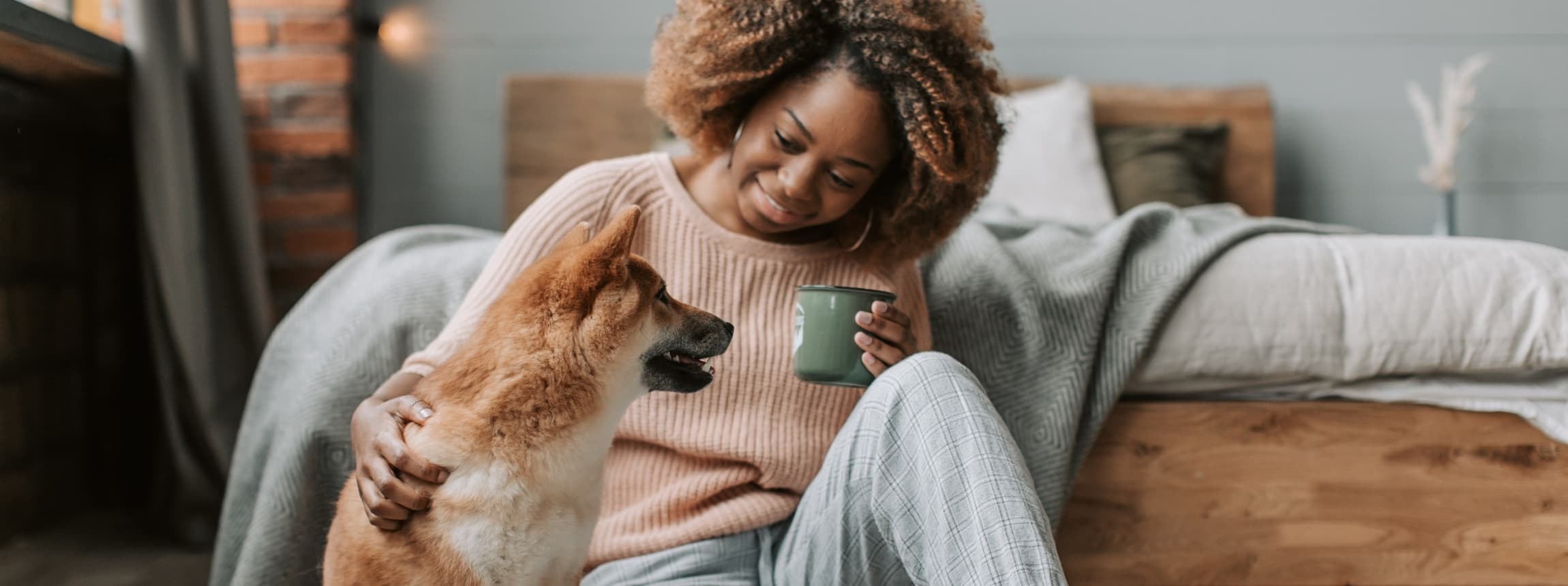 Woman smiling peacefully at home with her dog β the grounding and healing that trauma care at Minnesota Mental Health Clinics supports